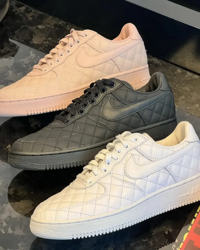 Three quilted Nike sneakers with swooshes: blush pink, black, and white, arranged on a dark surface