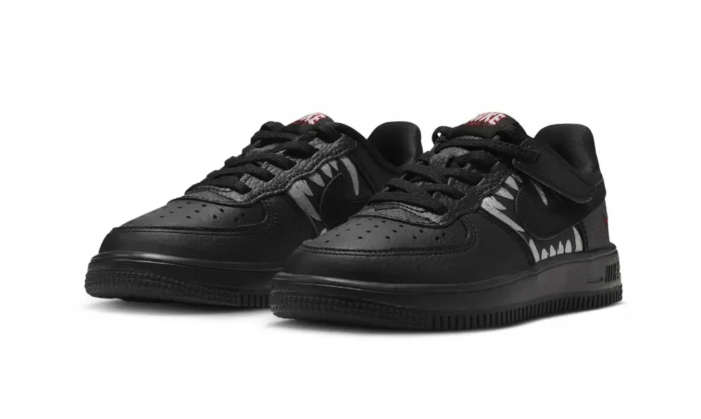 Pair of black low-top shoe with black lace, textured panels, white graphic accents and thick rubber sole on white