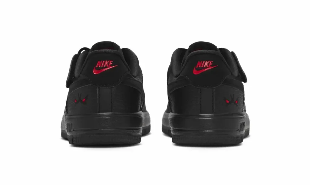 Rear view of black Nike shoe with red logos and butterfly-like heel detail on a white background