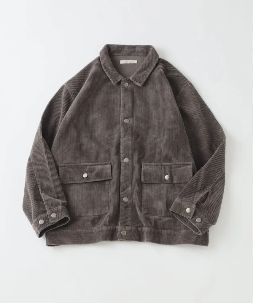 Brown corduroy jacket laid flat, with a pointed collar, snap buttons, and two flap pockets on a white background