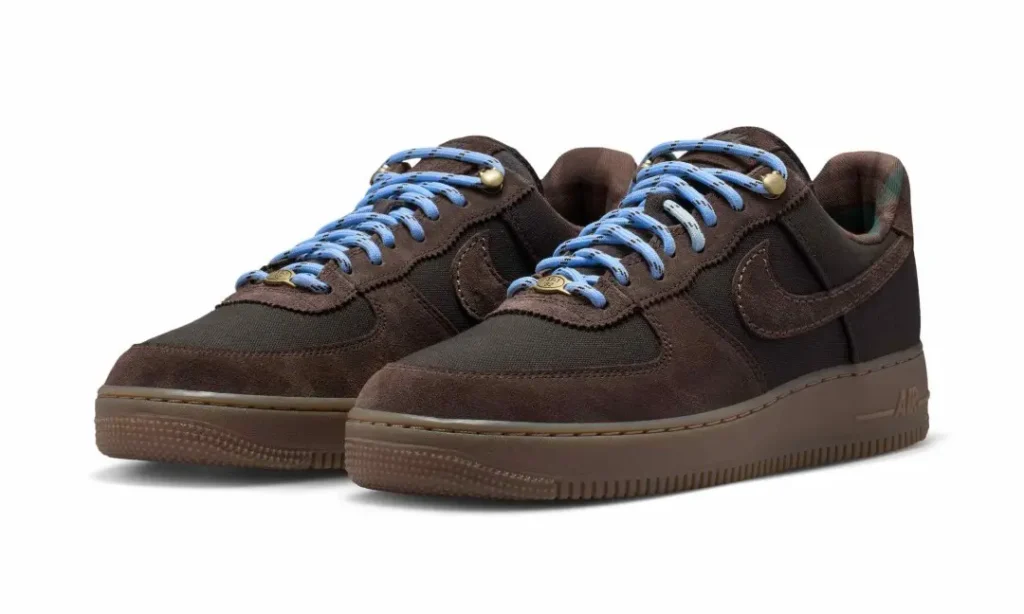 Pair of dark brown Nike Air Force 1 sneakers with bright blue laces on a white background