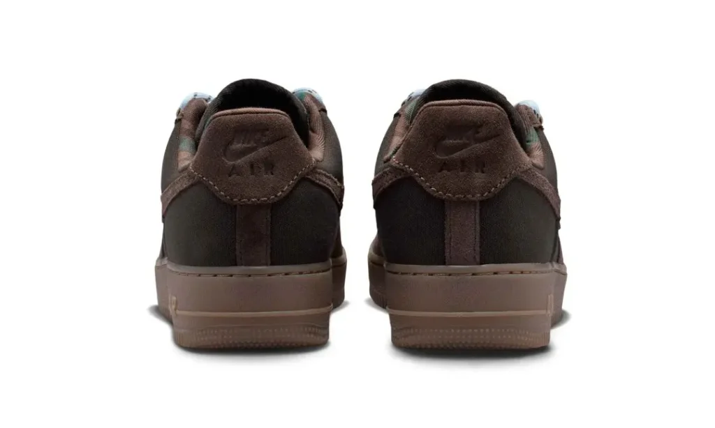 Rear view of a pair of dark brown Nike Air Force 1 sneakers with matching brown soles on a white background