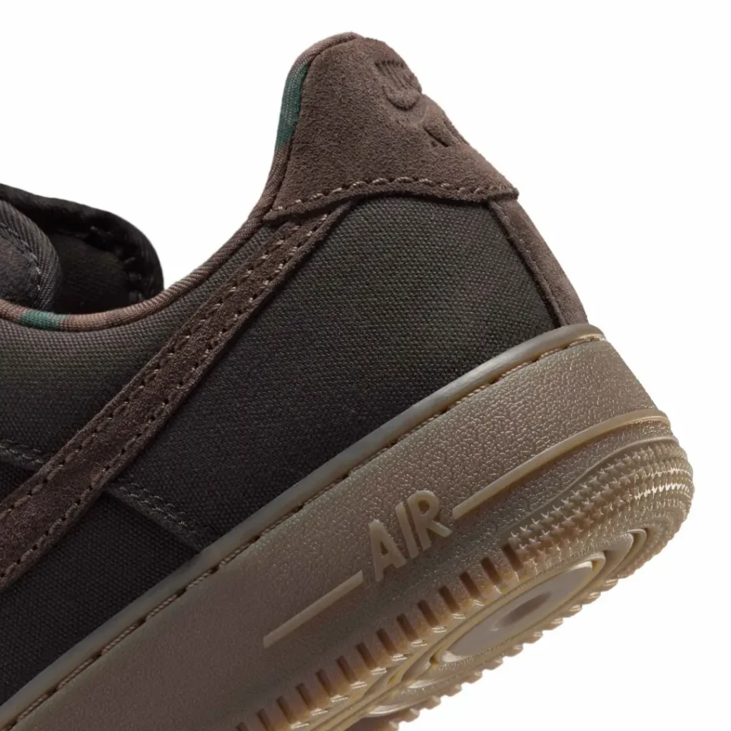 Close-up of a black and brown sneaker heel with textured fabric, stitched panels, and AIR branding on the gum sole