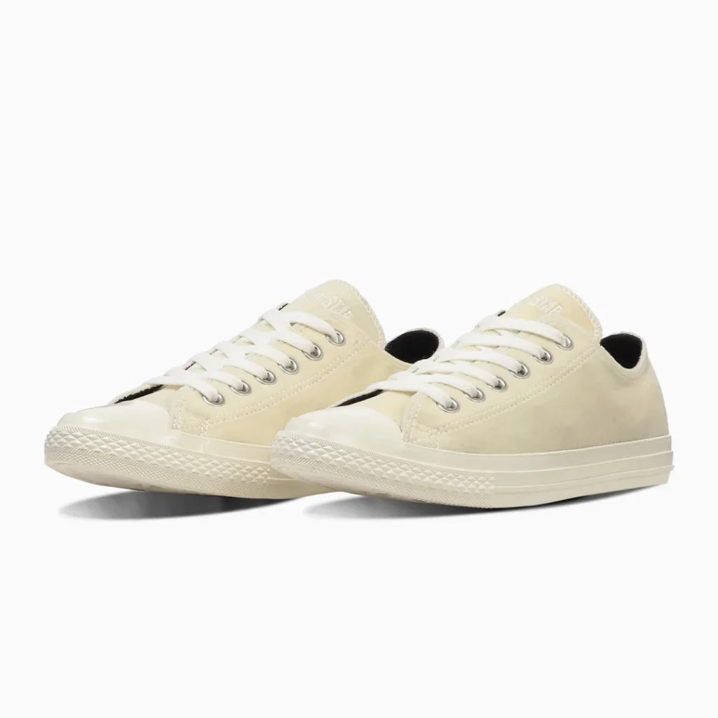 Pair of cream low-top shoe with white laces, rubber toe caps and textured soles on a white background