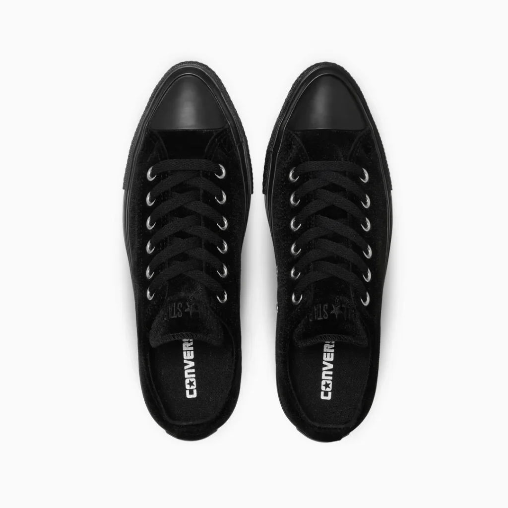 Pair of black Converse lace-up shoe viewed from above on a white background, with silver eyelets and white logos inside