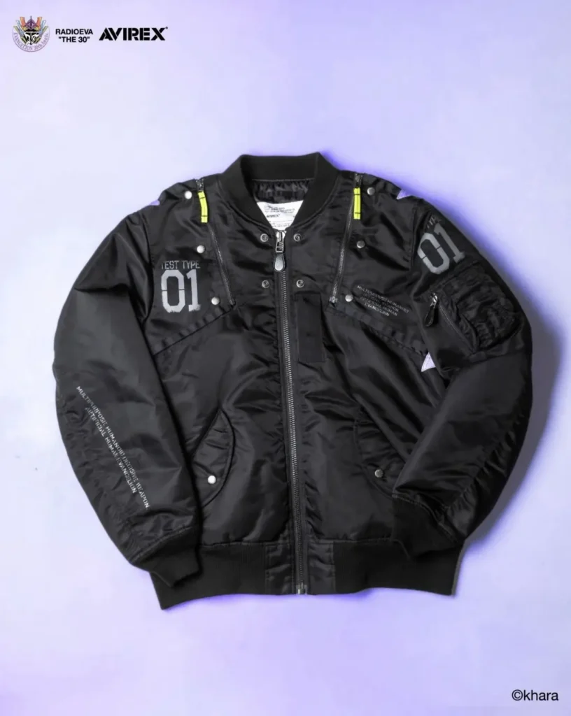 Black satin MA-1 bomber jacket laid flat, with neon yellow zipper accents, gray “01” patches and multiple pockets on a