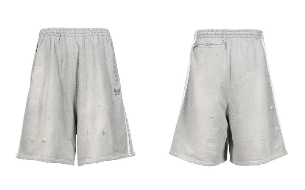 Front and back views of light gray distressed cotton jersey shorts with zip pockets, elastic waistband, and butterfly logo