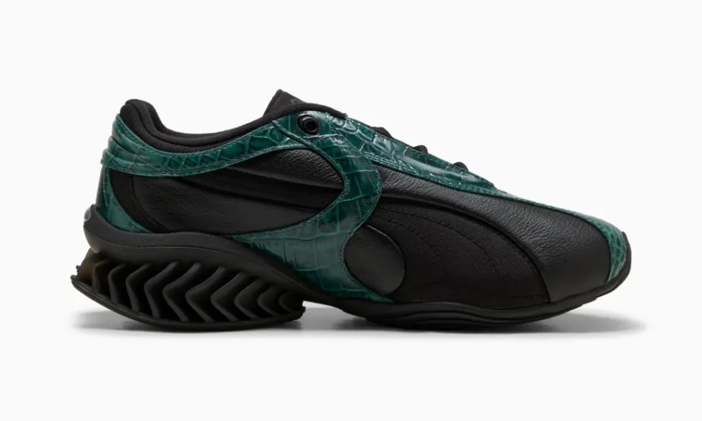 Black sneaker with dark green crocodile-textured overlays and a sculpted zigzag sole, shown in side profile on white