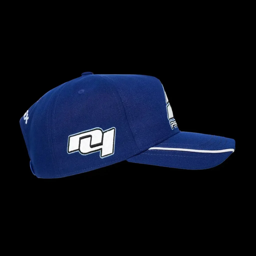 Blue baseball cap with white logos and a white stripe along the brim, shown against a black background