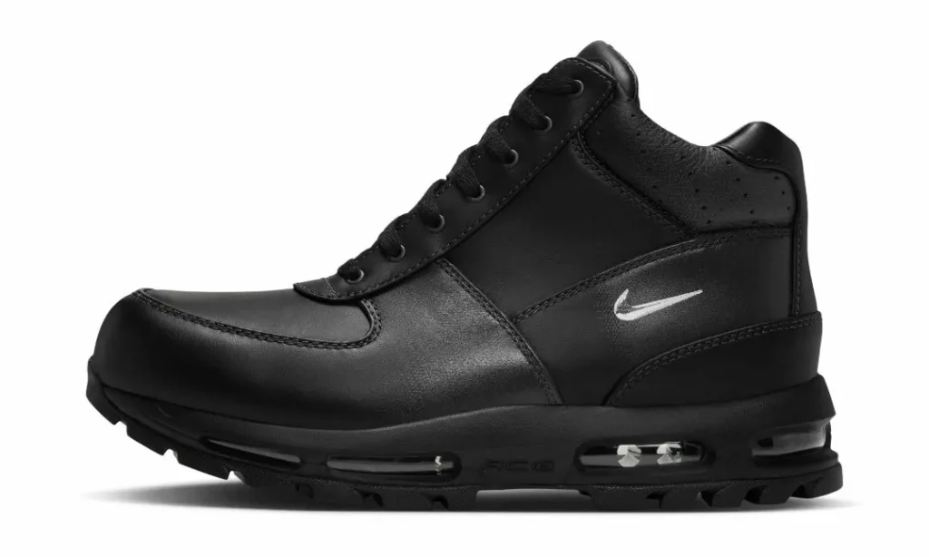 Black Nike mid-top sneaker with laces, white swoosh, rugged tread, and visible air cushioning on a white background