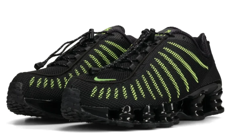Pair of black Nike sneakers with neon green striped detailing and segmented soles on a white background