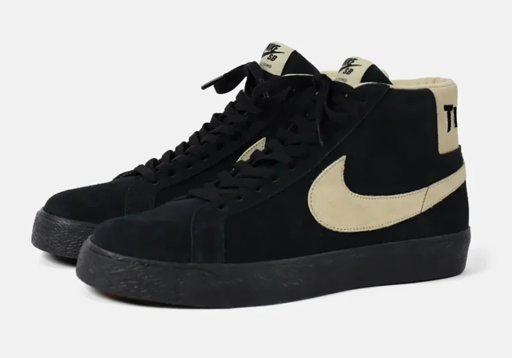 Pair of black Nike high-top sneakers with cream swooshes and heel collars on a white background