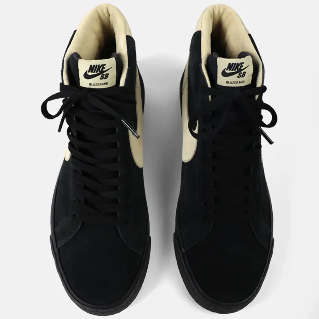 Pair of black Nike SB Blazer Mid sneakers with cream padded collars and tongues, shown from above on a white background