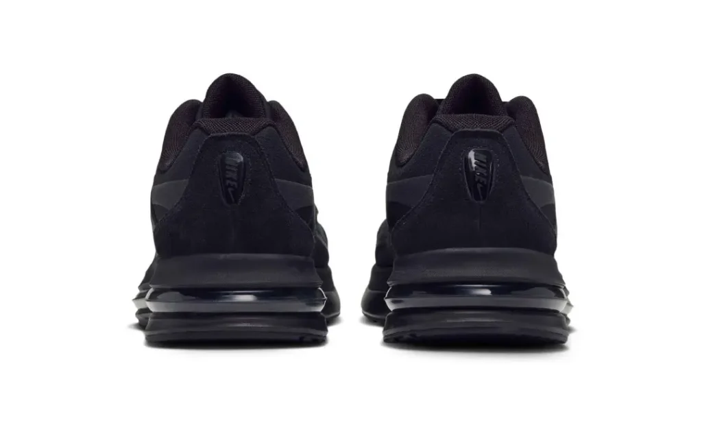 Rear view of a pair of black Nike Air Max shoe with layer soles on a white background