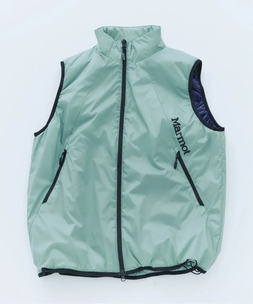 Mint green Marmot insulated vest with black zippers, high collar, zip pockets and purple lining, laid flat on white