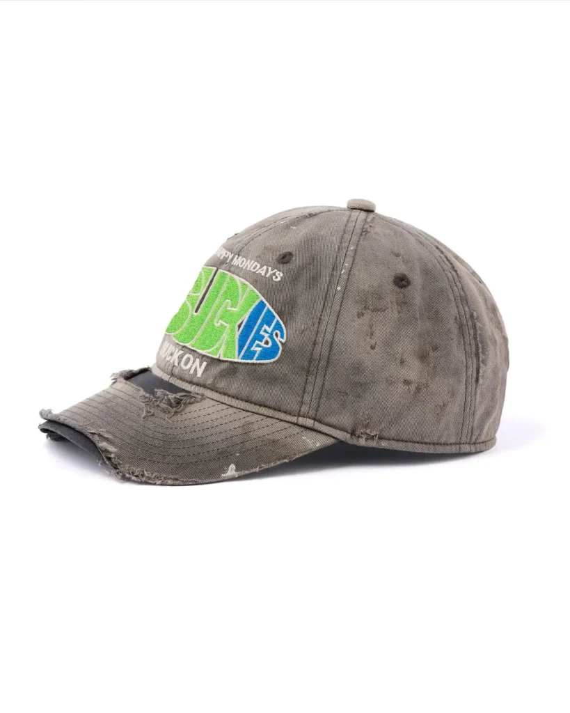 Distressed gray baseball cap with frayed brim and bright green-and-blue embroidered lettering on a white background