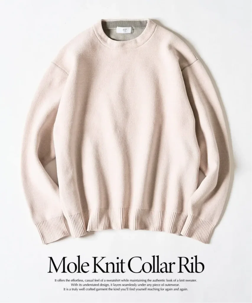 Pale pink crewneck knit sweater with ribbed collar, cuffs, and hem, laid flat against a white background