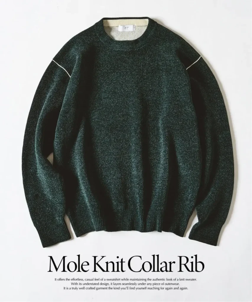 Dark green crewneck knit sweater with contrasting seam details, laid flat on a white background with text below