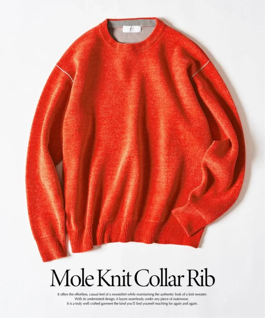 Bright red crew-neck knit sweater laid flat on a white background, with ribbed collar, cuffs and hem and white sleeve seam