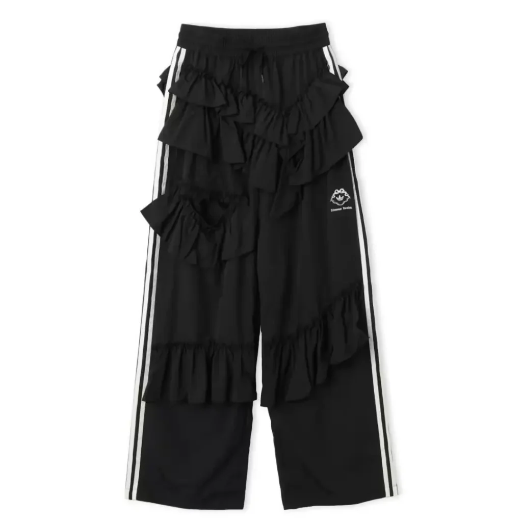 Black wide-leg pants with white side stripes, layered ruffles, elastic waistband, and small embroidered logo on white