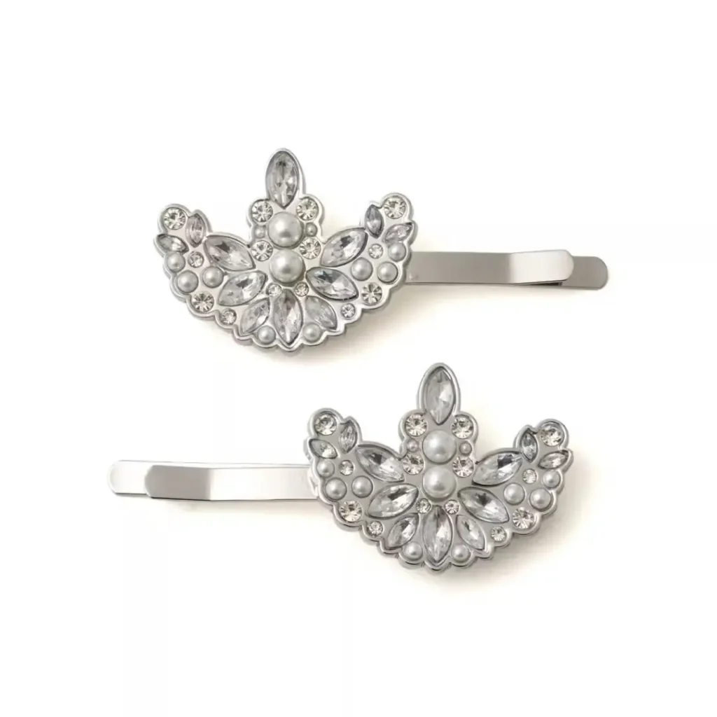 Two silver hair clips with floral designs, pearls, and faceted rhinestones on a white background