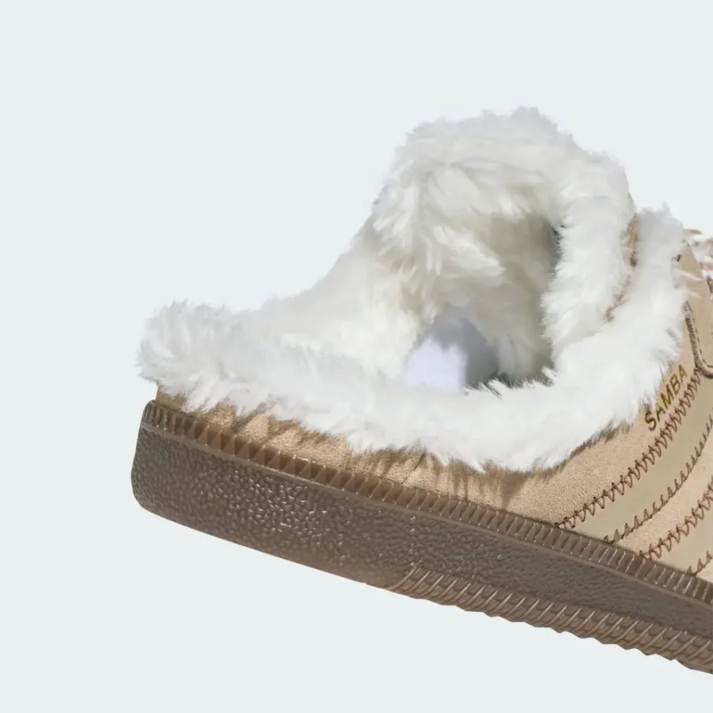 Close-up of a white plush-lined beige sneaker with textured brown sole and visible stitching against a pale background