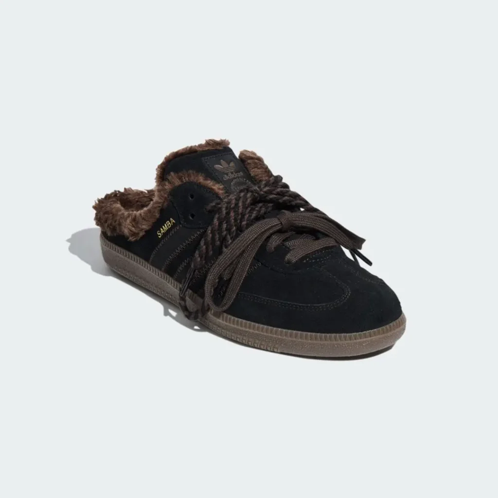 Black Adidas Samba sneaker with brown shearling lining, oversized laces and gum sole on a pale background