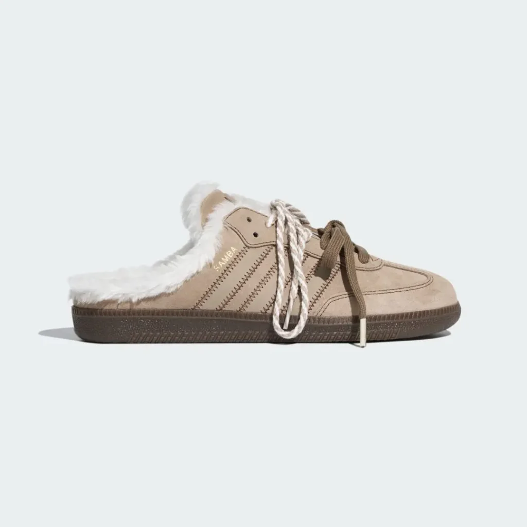 Tan suede sneaker with white faux-fur lining, dark rubber sole, and mismatched beige and white laces on a pale background