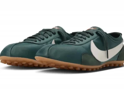 Pair of dark green low-top shoe with white swooshes, black laces and gum-colored lugged soles on white background