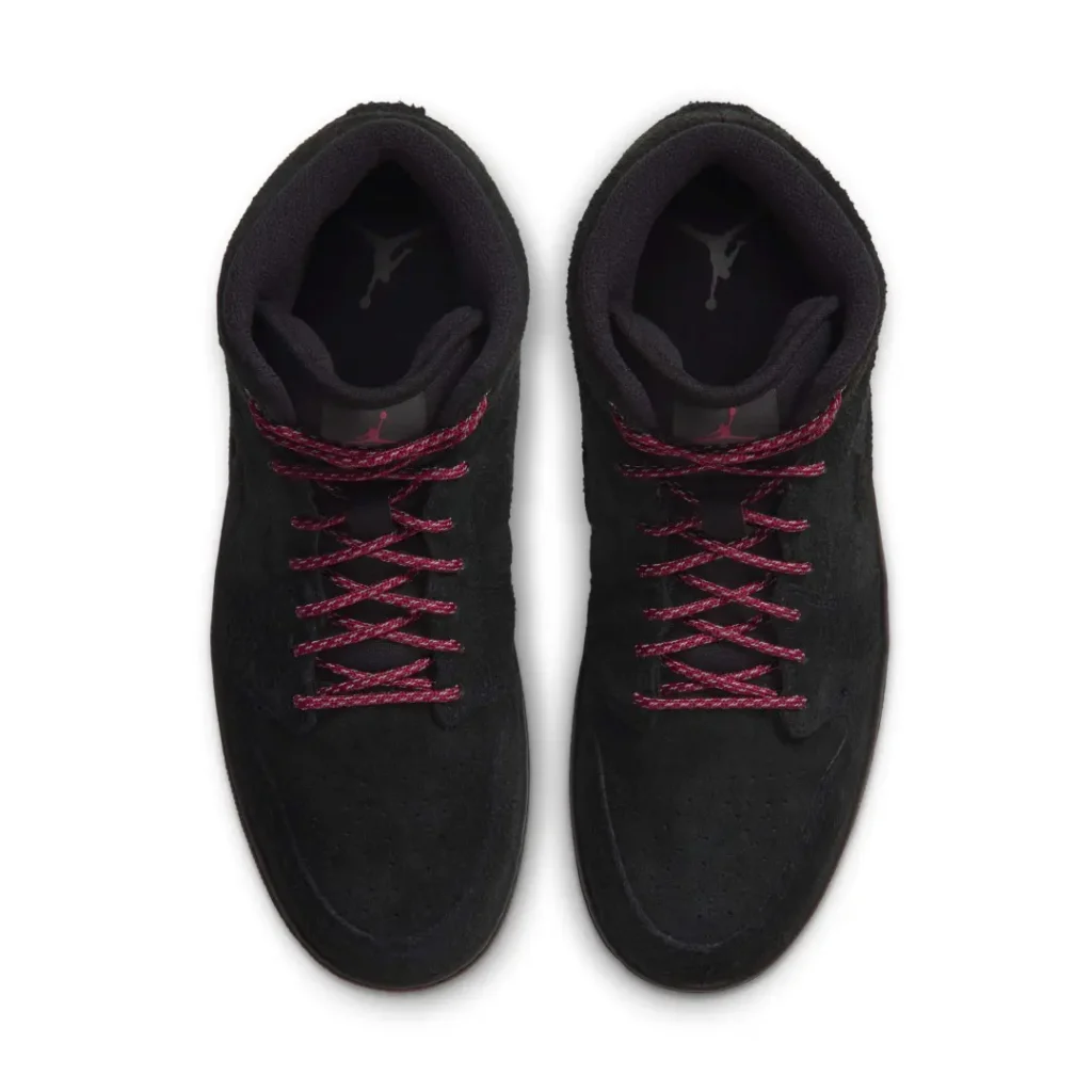 Pair of black low-top shoe with red laces and small Jordan logos, viewed from above on a white background