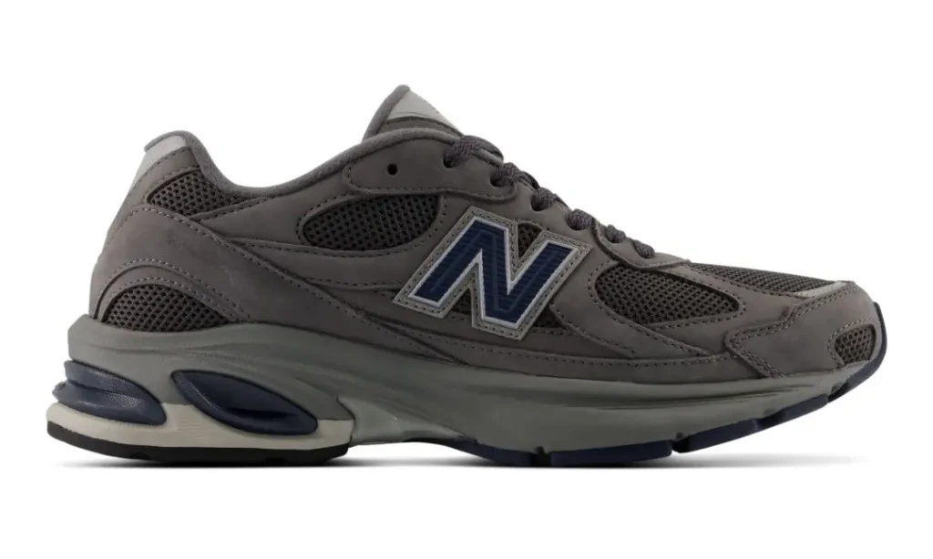 Gray New Balance sneaker with navy accents, mesh panels, and a chunky sole on a white background