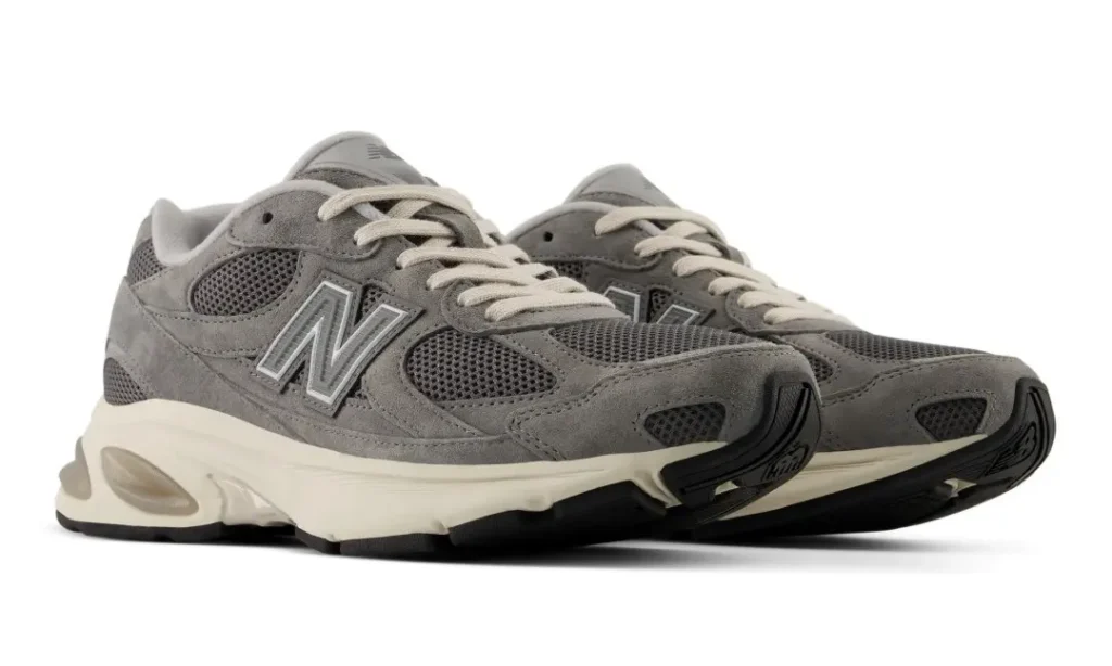 Pair of gray New Balance shoe with mesh and suede uppers, cream laces and midsoles on a white background