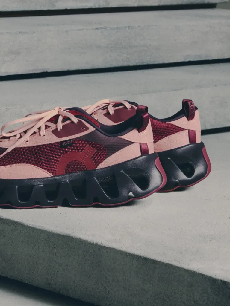 Pink and burgundy knit sneakers with black segmented soles resting on concrete steps