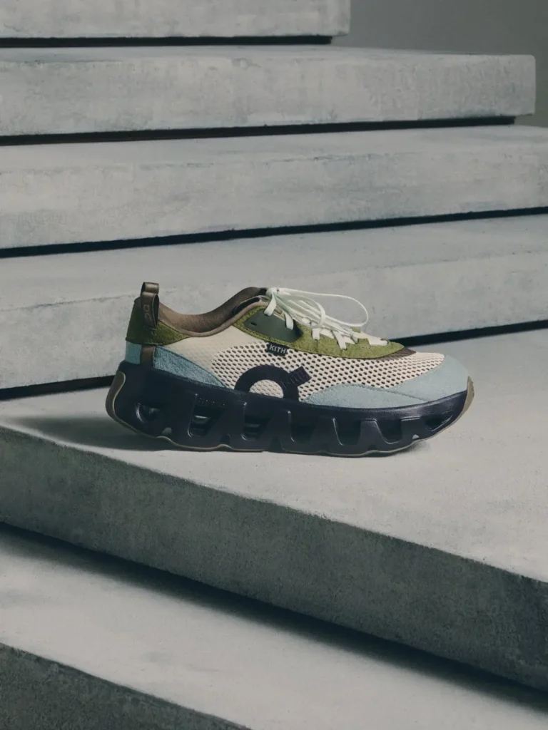 Cream and olive mesh sneaker with white laces and chunky black sole resting on concrete steps