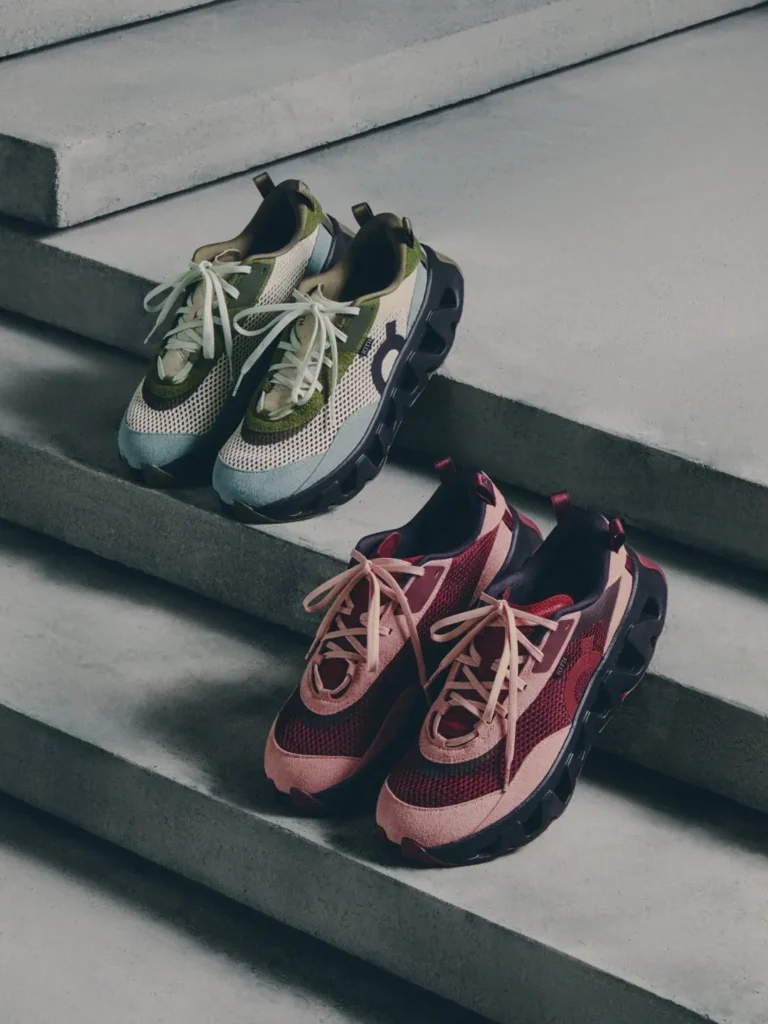 Two pairs of mesh sneakers with white laces, one green and white and one pink and black, arranged on concrete steps