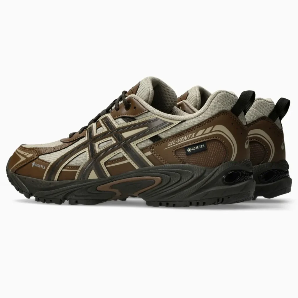 Pair of brown and beige trail running shoes with black soles, Gore-Tex labels and mesh panels on a white background