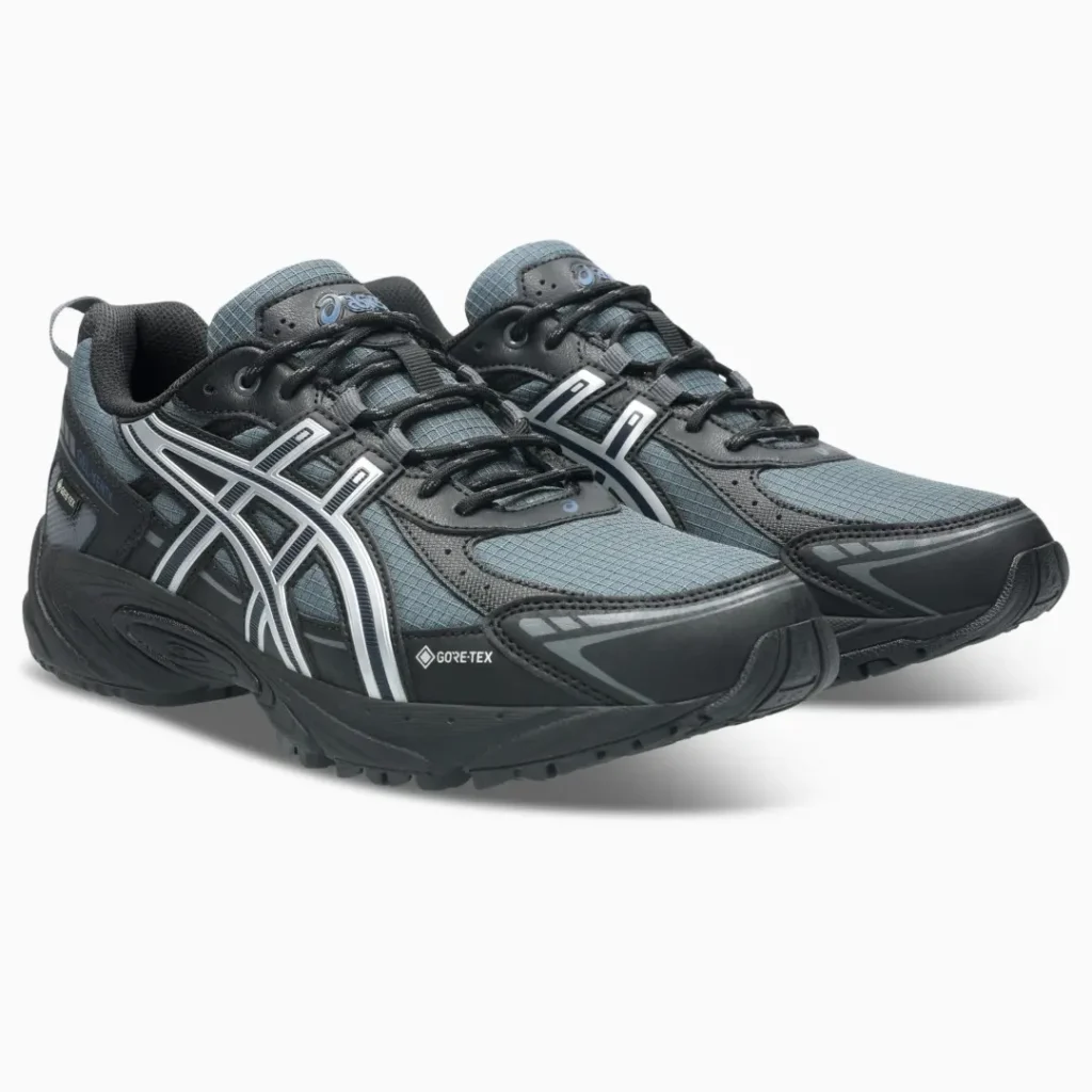 Pair of dark gray and black ASICS trail shoes with white logos and Gore-Tex labels on a white background