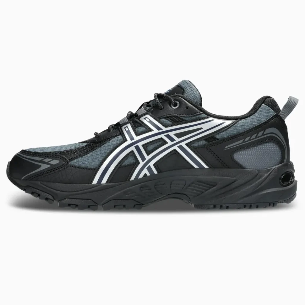 Black and gray trail shoe with white side stripes, rugged sole, and heel pull tab on a white background