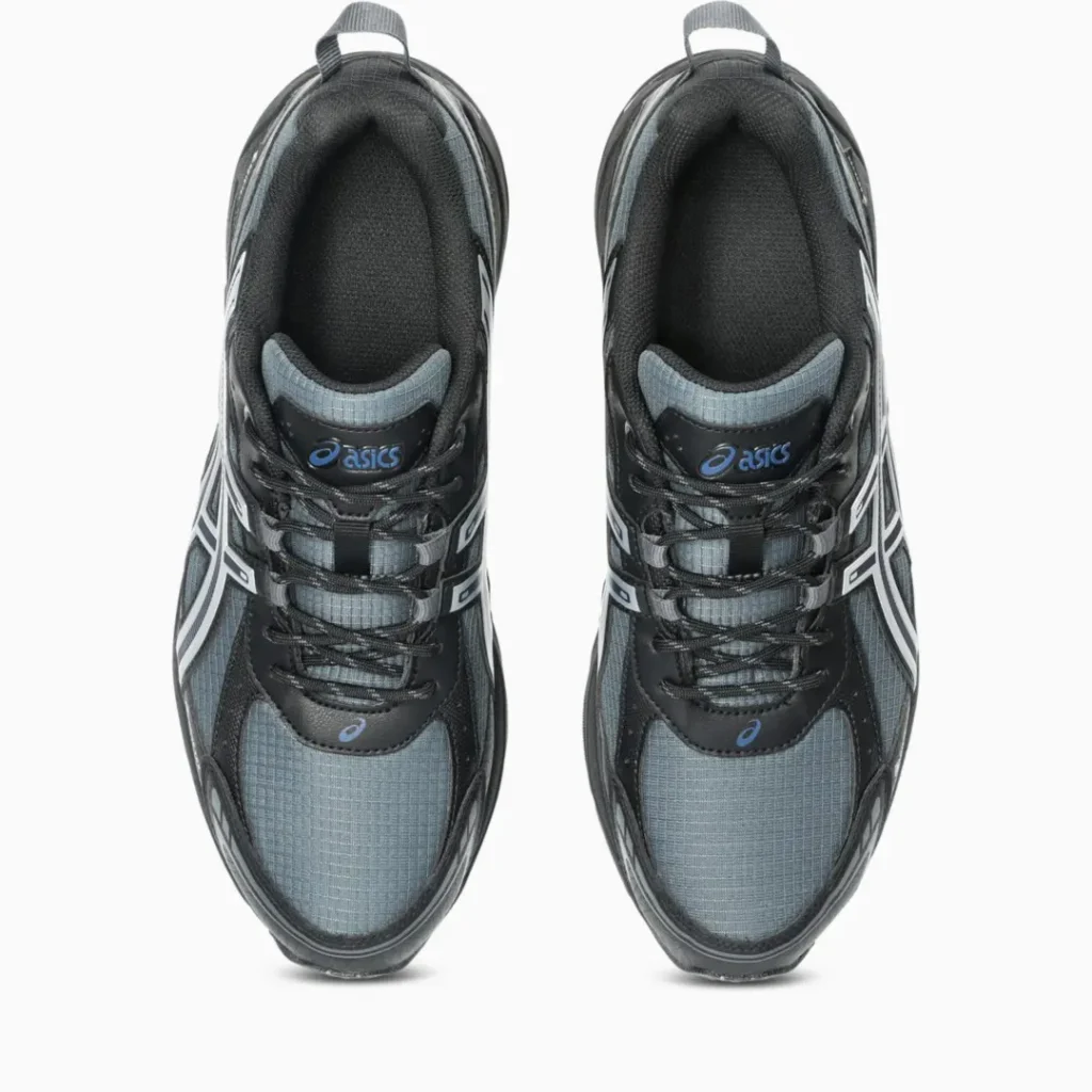 Top-down view of a pair of black and gray ASICS sneakers with laces and mesh panels on a white background