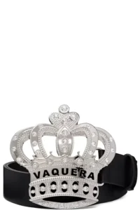 Silver crown-shaped belt buckle with rhinestones and “VAQUERA” lettering on a black leather belt against a white background