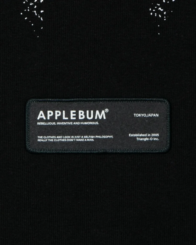 Close-up of a black garment with a stitched APPLEBUM label featuring white text and Tokyo, Japan branding