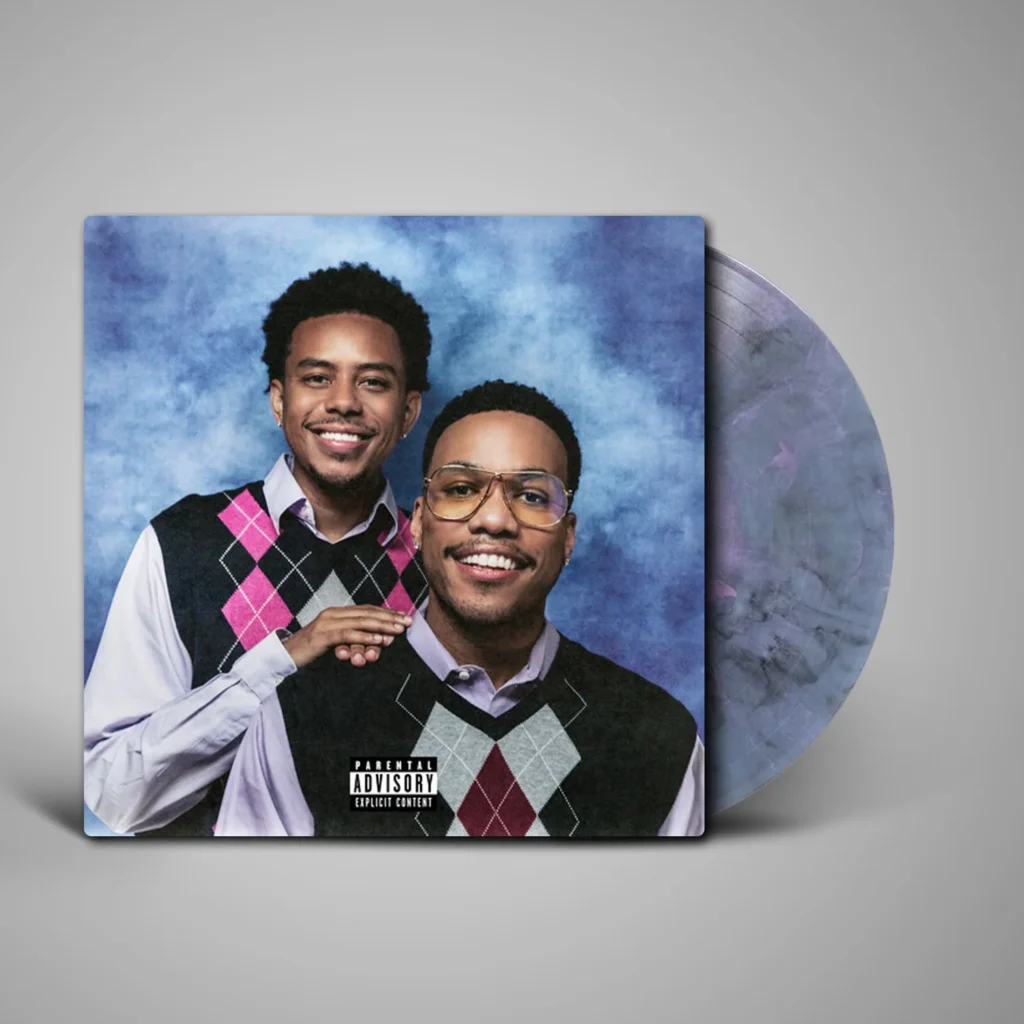 Anderson .Paak and Cordae pose together in argyle sweater vests, shown on a blue album cover beside a vinyl record