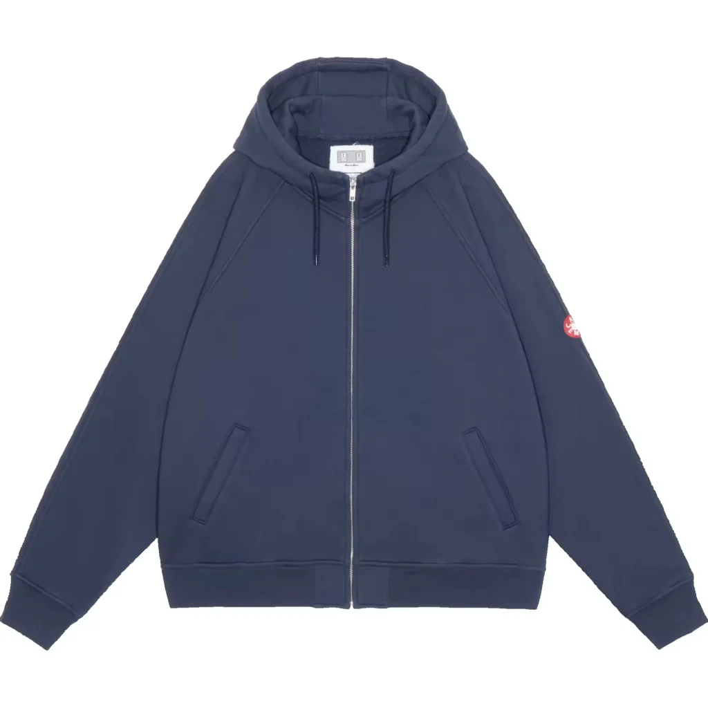 Navy hooded zip-up jacket with drawstrings, angled pockets, ribbed hem and a red sleeve patch, displayed on white background