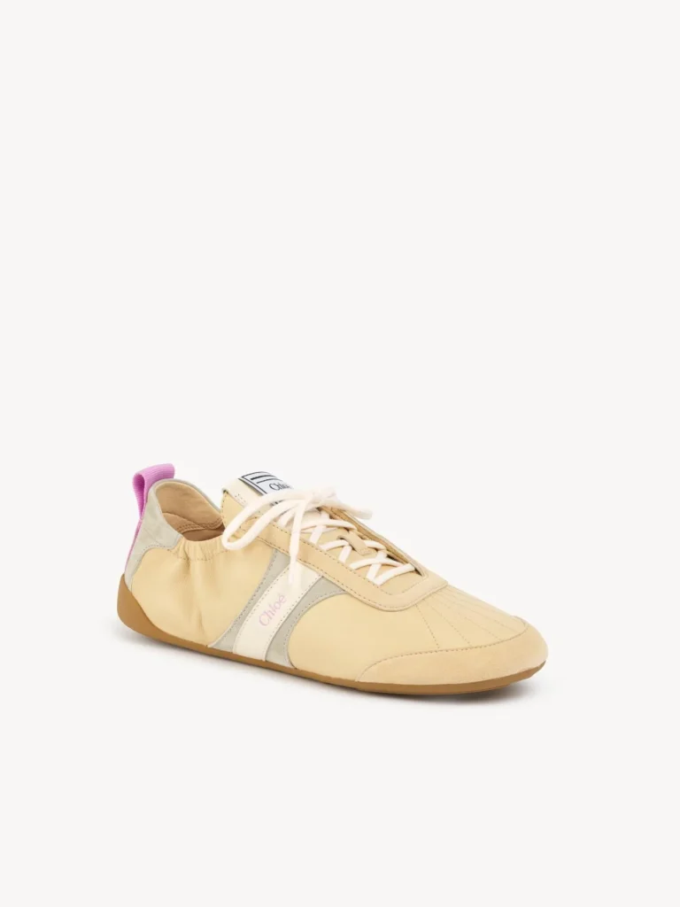 Cream Chloé low-profile sneaker with white laces, pale gray panels, pink heel pull tab and gum sole on white background