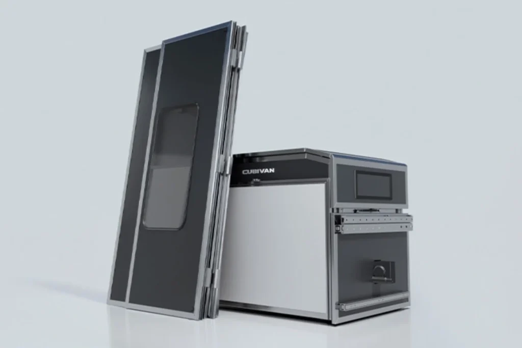 Dark gray Cubivan camper module with a compact kitchen and tall folded roof panel displayed against a white background