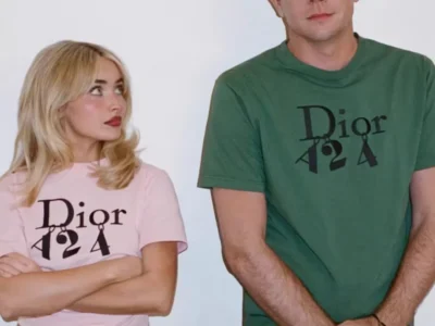 Sabrina Carpenter in a pink Dior Tee stands with folded arms beside Jonathan Andersonm in a green Dior Tee against a white background