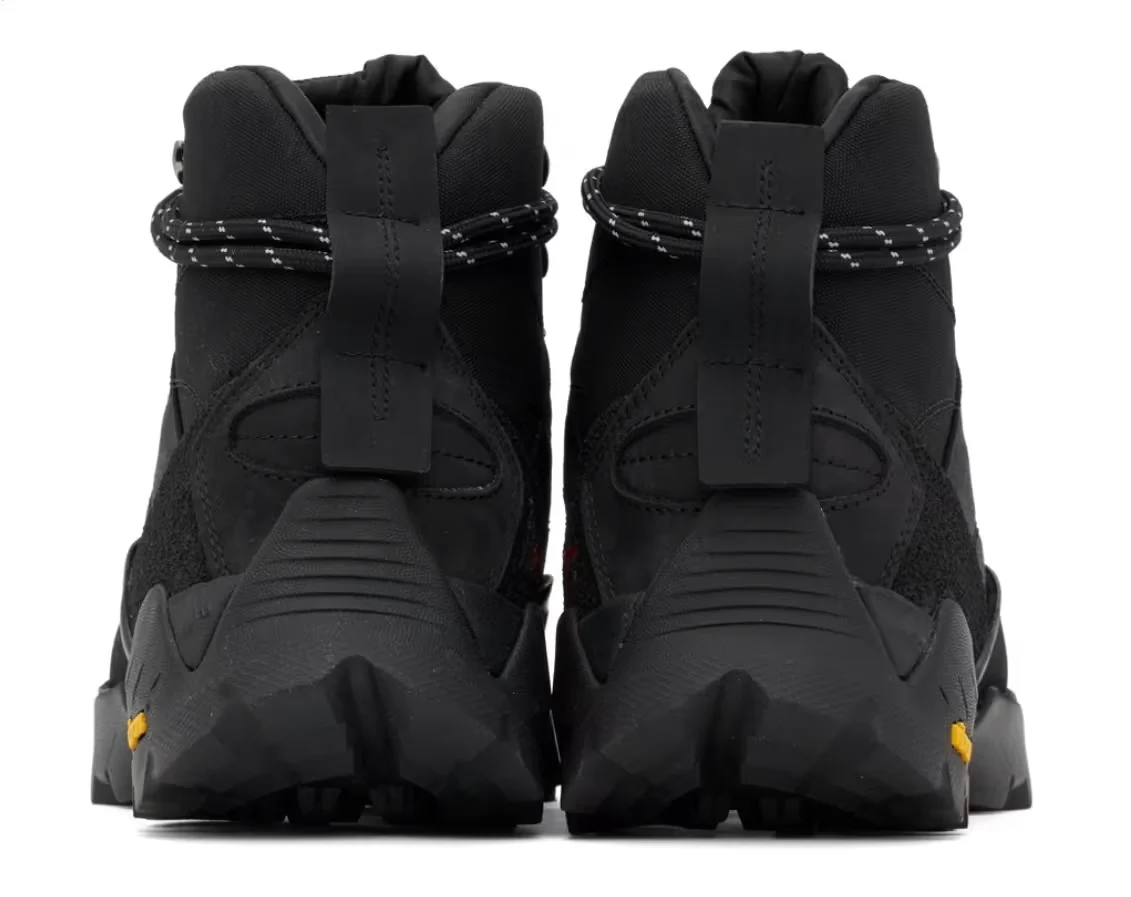 Pair of black high-top hiking shoes with thick soles, front straps, and speckled cord lacing on a white background