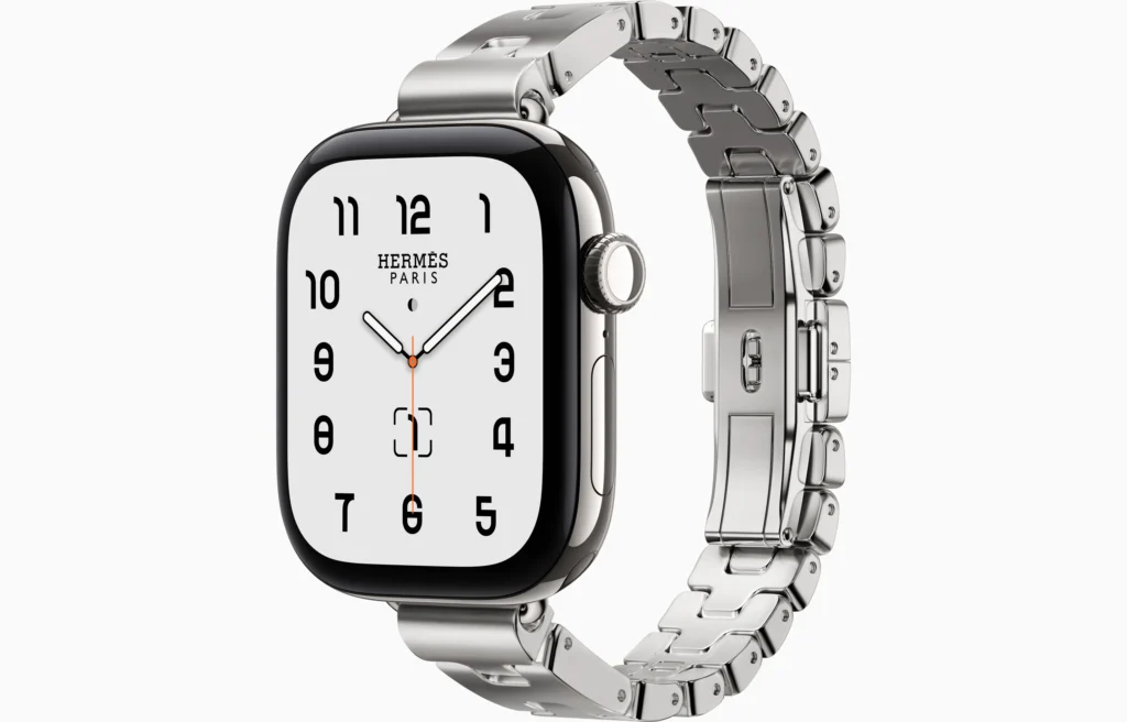 Silver Hermès Apple Watch with black bezel, white numbered face, and articulated metal link bracelet on white background