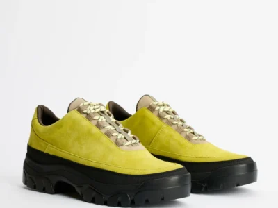 Pair of lime-green suede shoe with cream patterned laces and chunky black lug soles on a white background