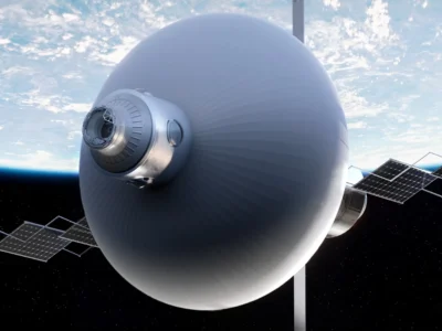 Large spherical spacecraft with a metallic front port and multiple solar-panel wings orbiting above Earth against a starry
